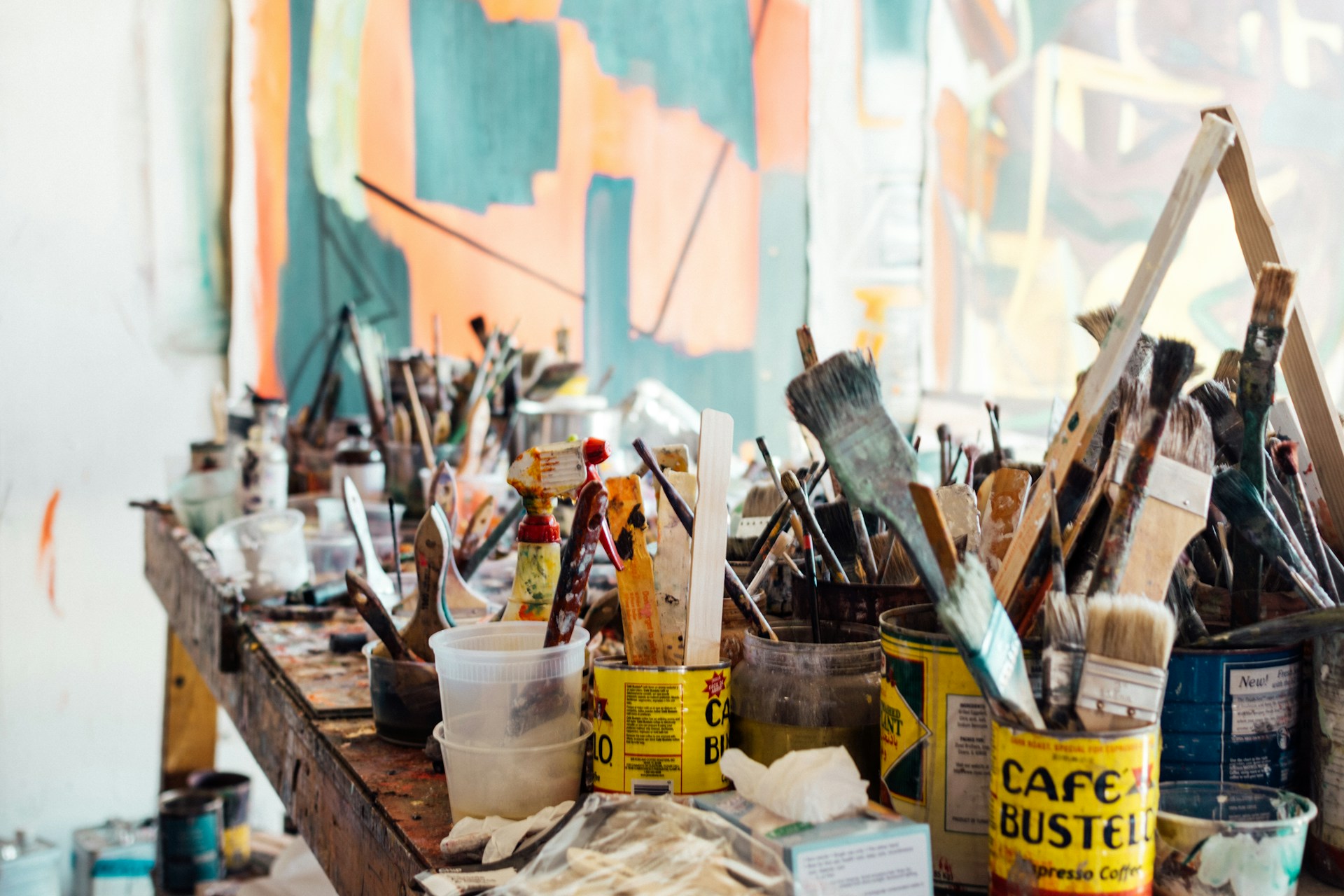 a cluttered desk of used paint brushes