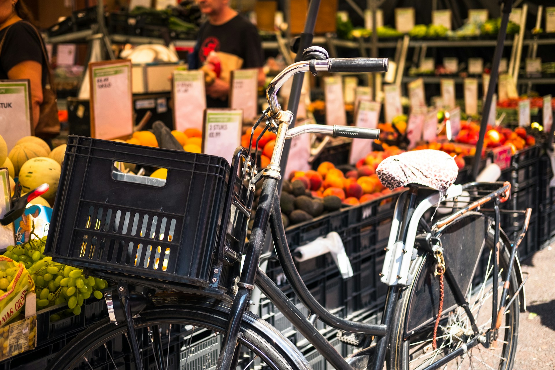 a bicycle parked in front of street market fruit crates